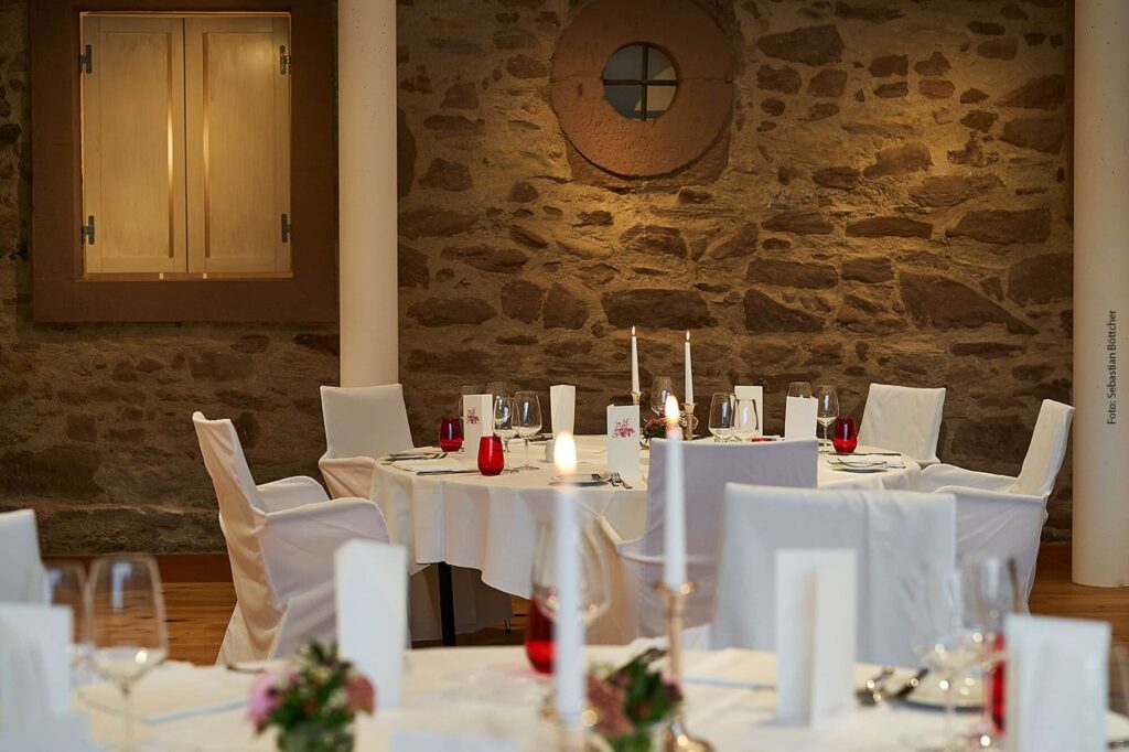 Stillvolle Stühle und gedeckte Tische im Hochzeitssaal