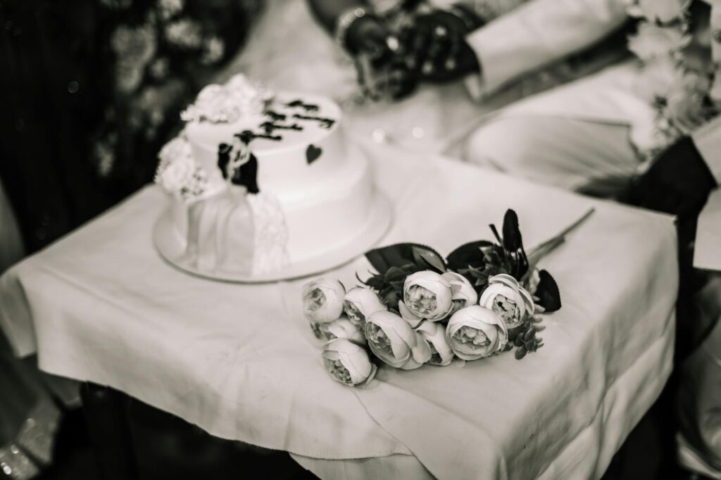 Elegante mehrstöckige Hochzeitstorte mit weißen Rosen – Symbol für Liebe und Tradition.