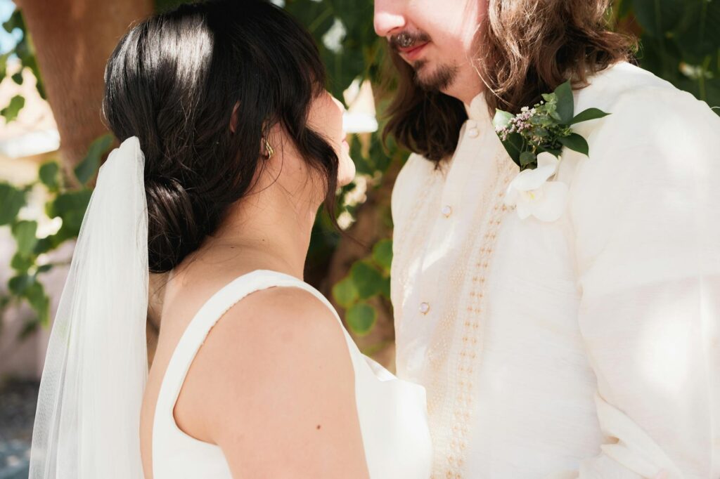 Braut und Bräutigam teilen einen zärtlichen Moment im Freien – Symbol für Liebe und Verbundenheit.